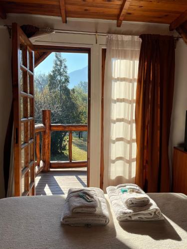 a bedroom with a bed and a sliding glass door at Cabaña Ruca Kushe in Lago Puelo