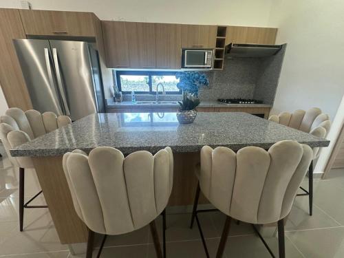 a kitchen with a table and chairs in a kitchen at Ecos del Mar 1 - Villa 31 · 3BR Tropical villa near Downtown in Punta Cana