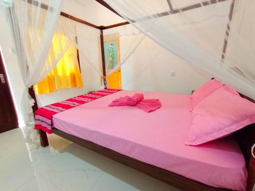 a pink bed with a bow on it in a room at Allan Guest Mirissa in Bandaramulla