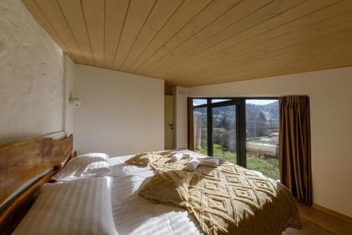 sypialnia z dużym łóżkiem i dużym oknem w obiekcie Domivka котедж із чаном-джакузі, каміном і кіно-зоною у Cлавську w Sławsku