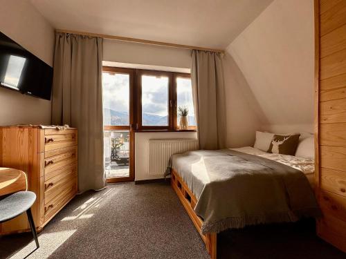 考斯赛力克Dom na Wierchu的一间卧室，里面有一张床和一扇大窗户。