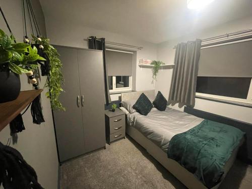 a small bedroom with a bed and a cabinet at Allon Manor De'Grey in Hull