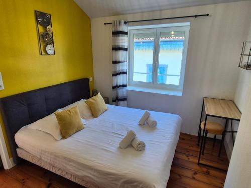 a bedroom with a bed with two towels on it at L'industriel - Lourdes Centre in Lourdes