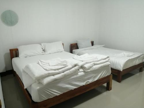 two beds with white sheets and towels on them at ชมวิว บึงโขงหลง in Ban Don Klang