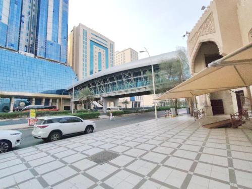 eine Stadtstraße mit Autos, die vor einem Gebäude geparkt sind in der Unterkunft فندق المسار العزيزية in Mekka