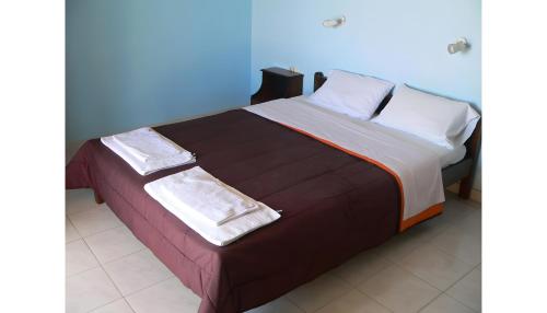 a bed with two towels on top of it at Apraos Bay Hotel in Apraos