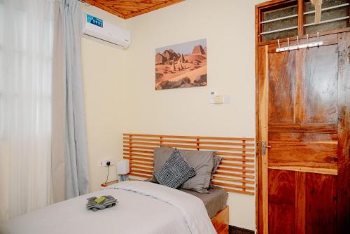 a bedroom with a bed and an open door at Roots and Waves Apartment in Zanzibar City