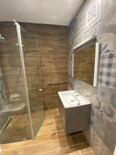 a bathroom with a shower and a sink and a mirror at Duplex Rim ,with swimming pool in Ḩammām al Ghazzāz