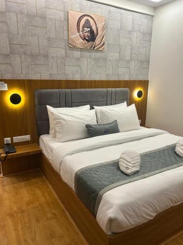 a bedroom with a large bed with white pillows at 69th Heaven Hotel in Devanhalli