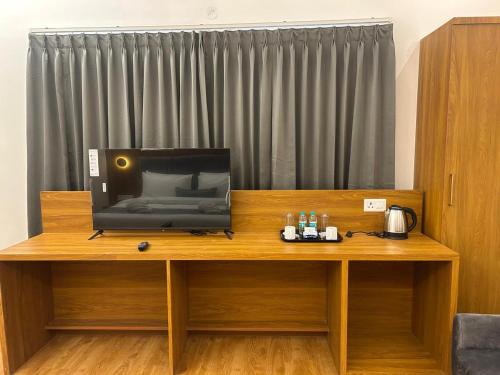 a television sitting on top of a wooden desk at 69th Heaven Hotel in Devanahalli-Bangalore
