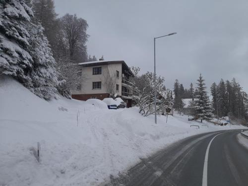 a road covered in snow next to a house at Apartmán 254 b in Janske Lazne