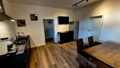 Wohnung zentral zwischen Gladbeck und Buer في غلادبك: غرفة معيشة مع مطبخ وطاولة طعام