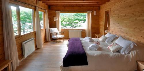 a bedroom with a large bed in a wooden house at Aguas Arriba Lodge in El Chalten