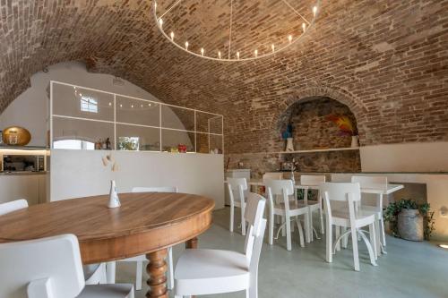 a dining room with a wooden table and white chairs at Villa Le Contrade - Rifugio nel Borgo Storico in Santarcangelo di Romagna