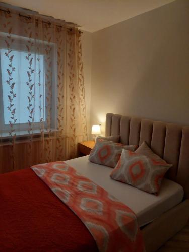 a bedroom with a bed with two pillows and a window at Link Kauno marių... in Kaunas