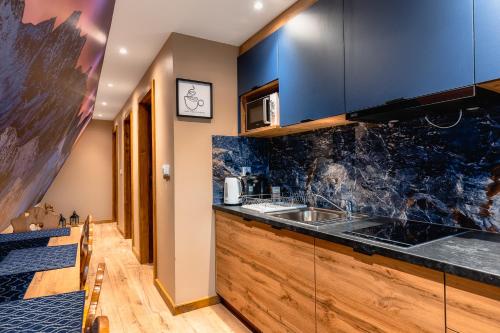 una cucina con lavello e microonde di Rolicek 4 Seosons Apartments a Zakopane