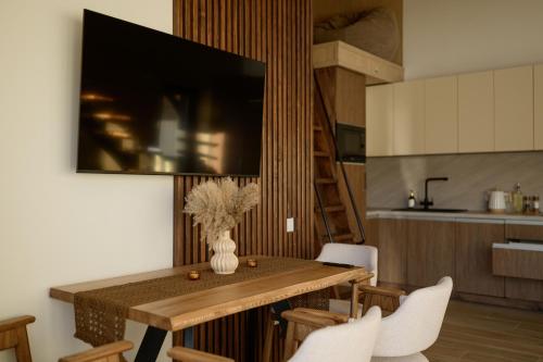 a kitchen with a wooden table with white chairs at Domivka котедж із чаном-джакузі, каміном і кіно-зоною у Cлавську in Slavske