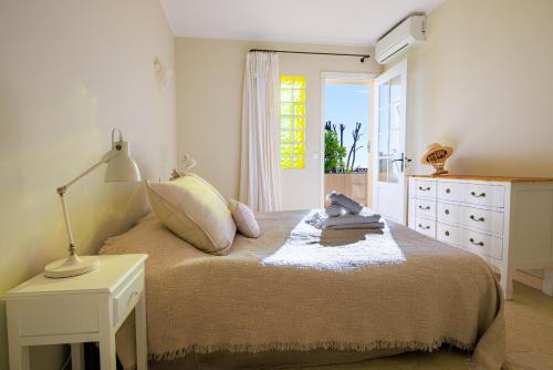 a bedroom with a bed with a lamp and a dresser at Villa Miradou in Saint Paul de Vence