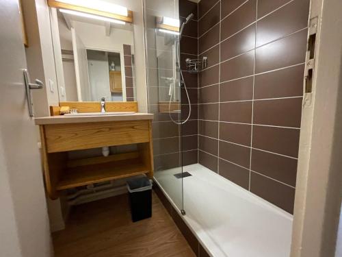 Un baño con ducha, lavabo y bañera. en Appartement residence bec aigle, en Le Lioran