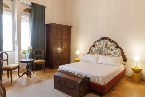 een slaapkamer met een bed, een tafel en stoelen bij La Corte del SignorB 