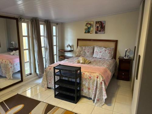 ein Schlafzimmer mit einem großen Bett und einem Nachttisch in der Unterkunft Casa Piccolo Paradiso 4 quartos in Balneário Gaivotas