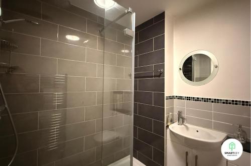 a bathroom with a shower and a sink and a mirror at Central Woking 2 Bedroom 2 Bath Modern Apartment with Parking in Woking