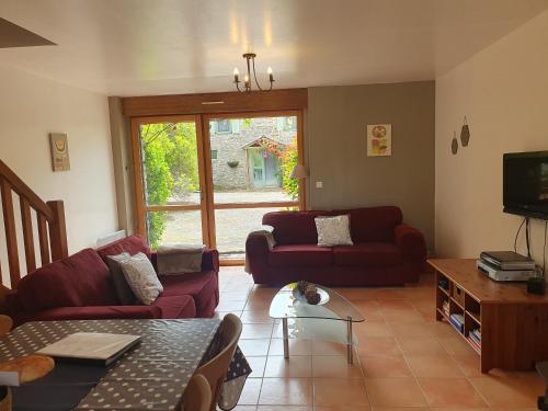 a living room with two couches and a tv at Moros in Melgven