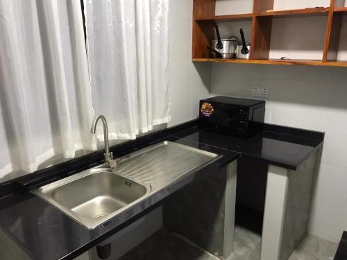 卢萨卡mck lodge ltd的带水槽和微波炉的厨房柜台