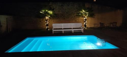Saint-Benoist-sur-MerLa Parenthèse à la Mer - Swimming Pool - Family的夜间游泳池,设有长凳和灯光