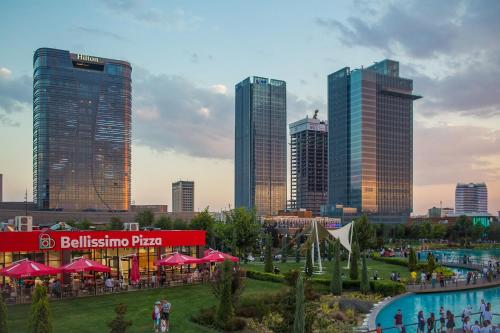 a group of people walking around a park in a city at Toshkent city apartments in Tashkent