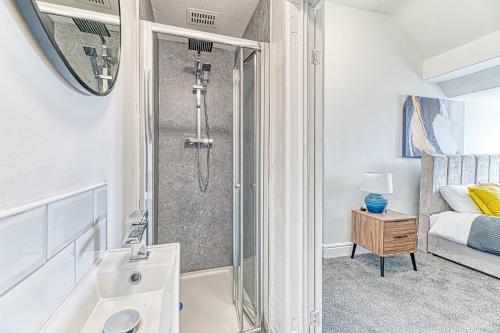 ein Badezimmer mit Dusche und Waschbecken und ein Bett in der Unterkunft Fairhaven View Apartments - Lytham St Annes in Lytham St Annes