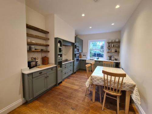 uma cozinha com uma mesa e cadeiras, uma mesa e um balcão em The Shrubbery-Superb Modern home-6 beds-sleeps 11 em Topsham