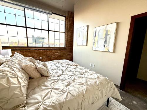 Un dormitorio con una cama grande con almohadas. en The Luxe Loft Boho Chic, en Duluth