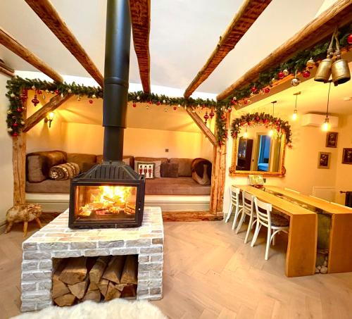 皮亚特拉-尼亚姆茨Barlogul Ursilor Ciubar&BBQ的带壁炉的客厅配有桌子