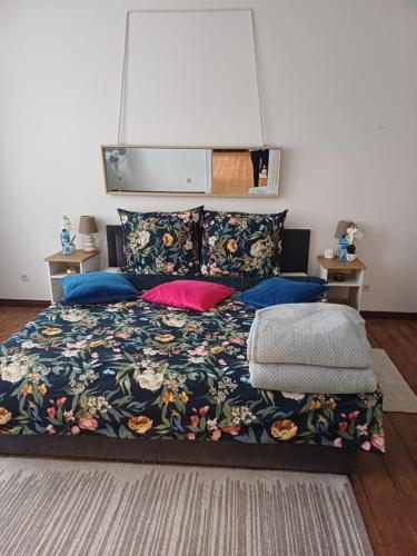 una camera da letto con un letto con copriletto e cuscini floreali di Zacisze Pod Nikiszem a Katowice