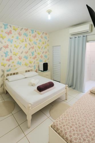 a bedroom with a bed and a wall with flowers at ꕥ Cantinho da Margarida ꕥ Hospedagem & Hostel Premium - 03 Opções - SUÍTE Privativa, CAMAS Hostel ou Meia CASA - 1 Km do CENTRO de Belém, Hangar, UFPA, Turismo e Eventos - Máximo CONFORTO com Wi-Fi Ultra Rápido e Café da Manhã Grátis! - HOTEL Belém Pará in Belém