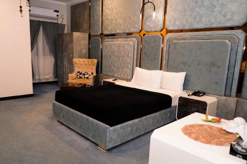 Un dormitorio con una cama, una silla y una mesa. en Hyatt Residency, en Islamabad