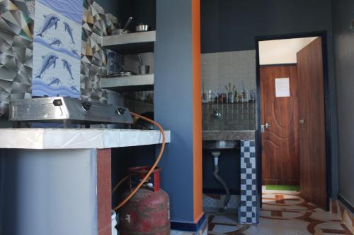 a kitchen with a sink and a wooden door at Morning Mist Home stay in Jorhat
