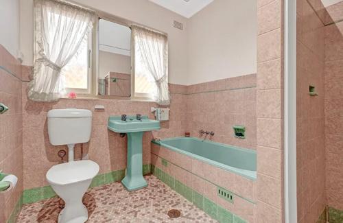 Un baño con inodoro, lavabo y bañera. en Quiet Guest Room in Burwood, en Sídney