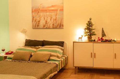 ein Schlafzimmer mit einem Bett mit einem Weihnachtsbaum darauf in der Unterkunft Spacious Studio Close to City Center l Washing Machine l Kitchen in Novi Sad