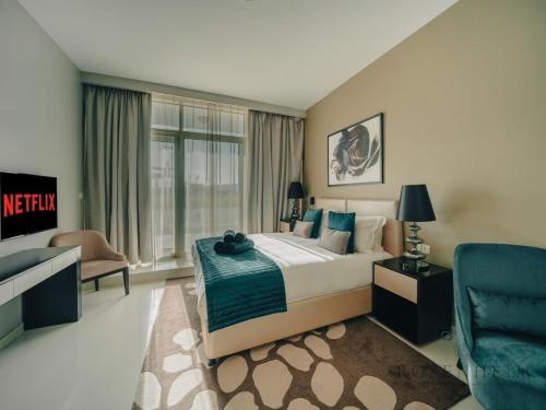 a bedroom with a king sized bed and a blue chair at Modern Studio Escape - Pool, Gym & Relaxation in Dubai
