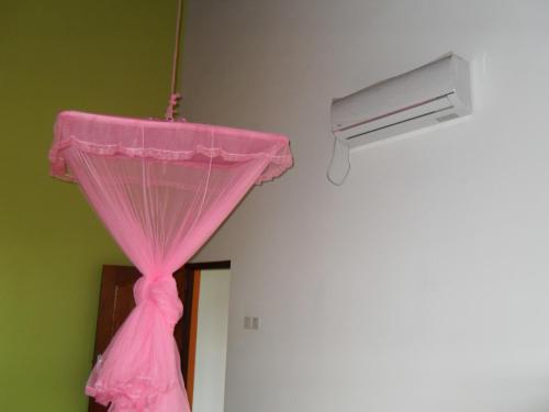 a pink curtain hanging from a ceiling in a room at Bee Nest Bed & Breakfast in Negombo