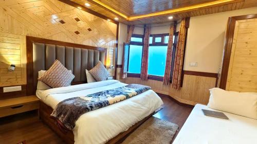 a bedroom with two beds and a window at Naini Lake View The- Gwen -Stays Mall Road - Lake View Rooms Types- Prime Location - Best Luxuary Hotel In Nainital in Nainital