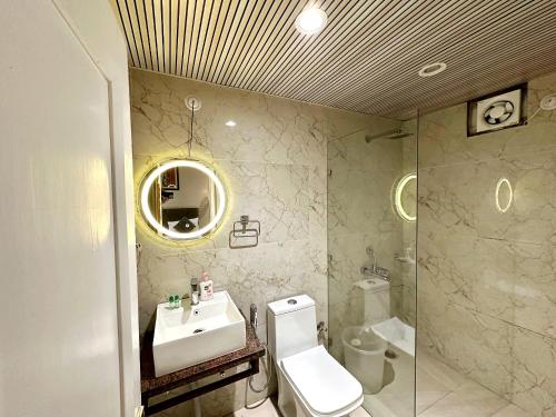 a bathroom with a sink and a toilet and a mirror at Naini Lake View The- Gwen -Stays Mall Road - Lake View Rooms Types- Prime Location - Best Luxuary Hotel In Nainital in Nainital