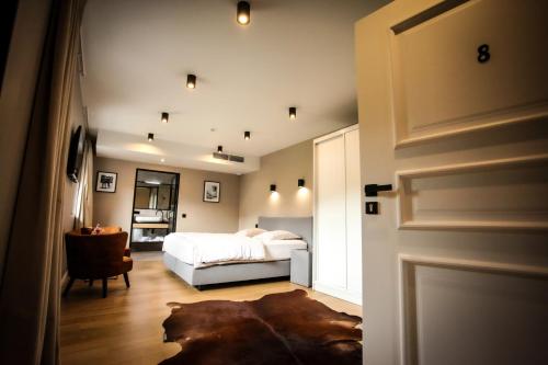 a bedroom with a white bed and a door at Ferme d'Ecavée in Celles