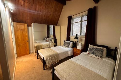 a bedroom with two beds and a mirror at Middle Pines Chalet in Warren