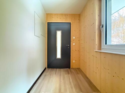 a black door in a room with a window at Treehouse - Alpinlake Apartments in Grünau im Almtal
