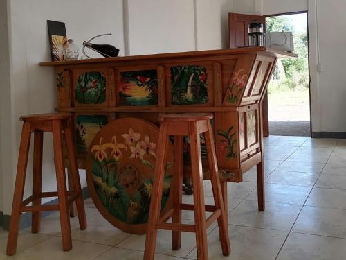 a wooden cabinet with two stools in a room at Aura Living in La Garita