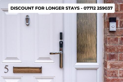 een witte voordeur met de woordkorting voor langere verblijven bij Modern 5 Bed House in Bedford Perfect For Contractors in Bedford