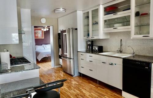 a kitchen with white cabinets and stainless steel appliances at Capitol Retreats-views! Near Salt Palace,sleep 28 in Salt Lake City